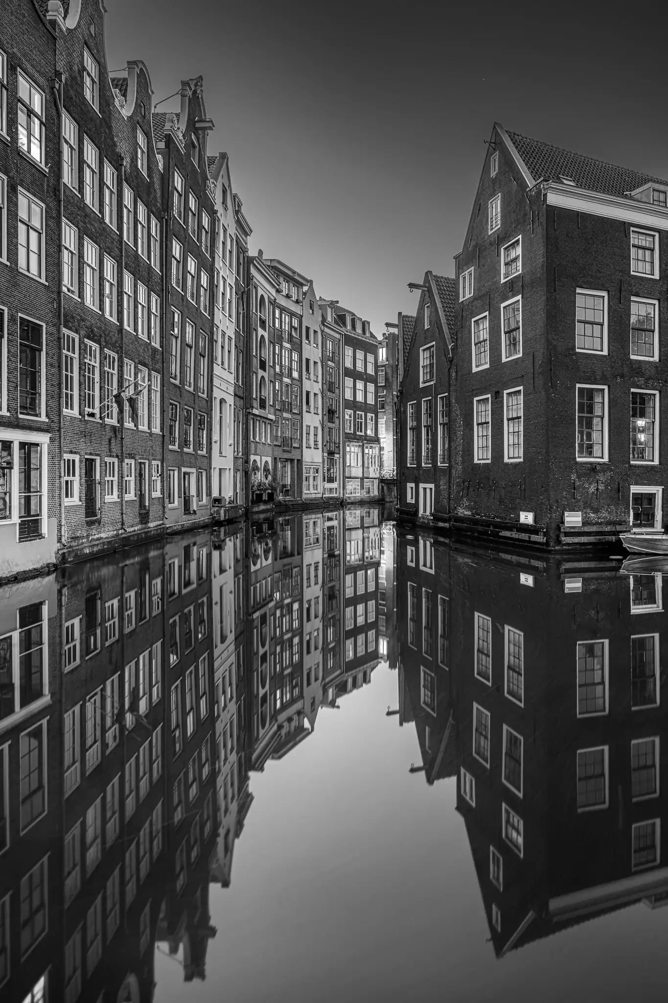 Amsterdam canal with architecture reflected in calm water