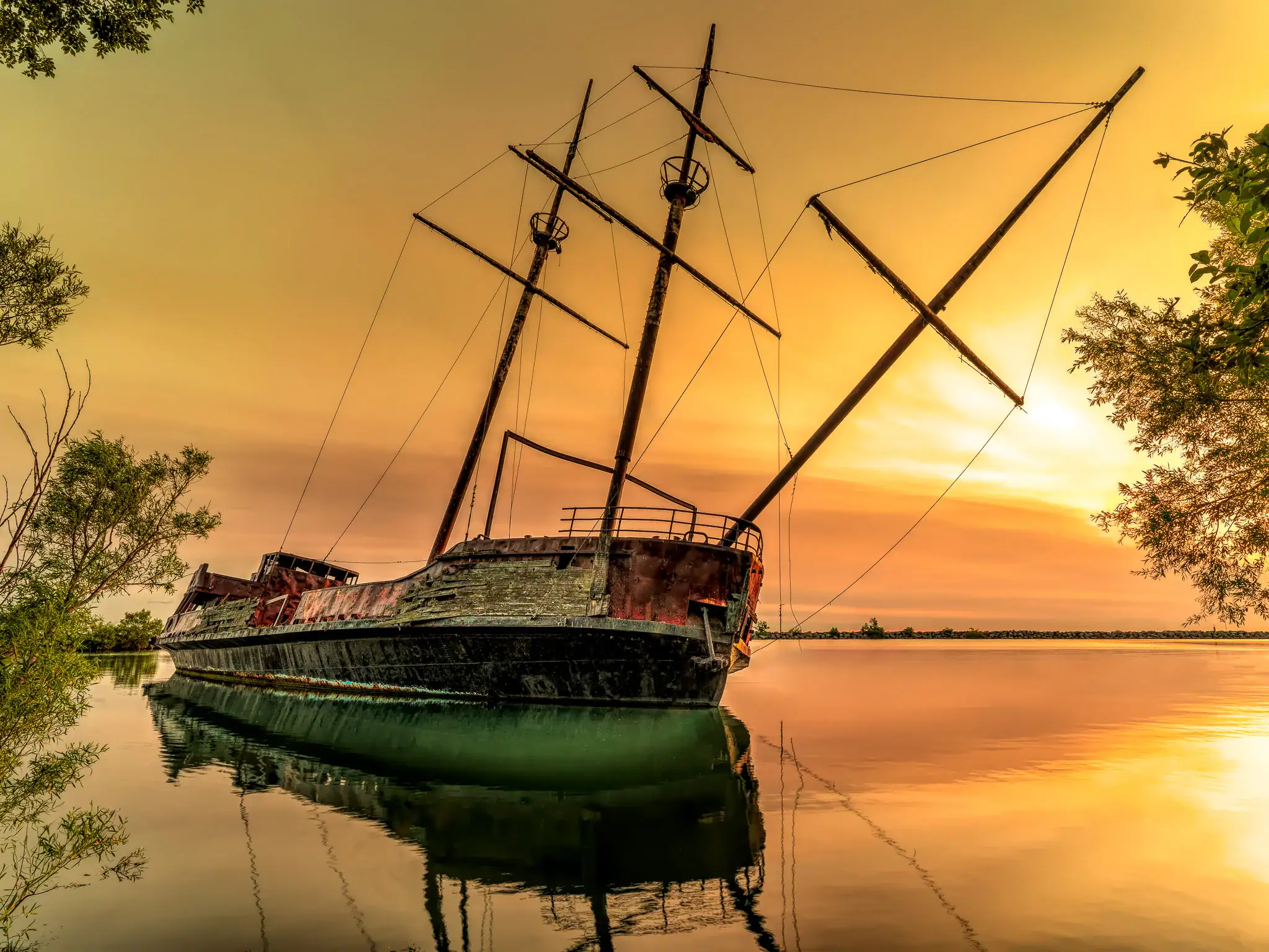Old shipwreck at sunrise on calm Lake Ontario in soft morning light